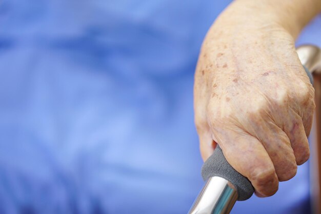 Die Hand einer älteren Frau oder einer älteren Person fängt den Walker Walker Cane zur Unterstützung