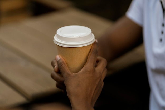 Die Hand einer Person aus nächster Nähe, die einem Freund, der sich um sie kümmert, einen Kaffee gibt