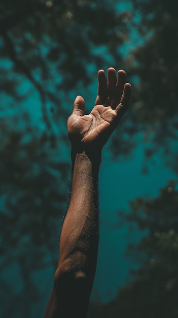 Die Hand einer Person, die in den blauen Himmel reicht