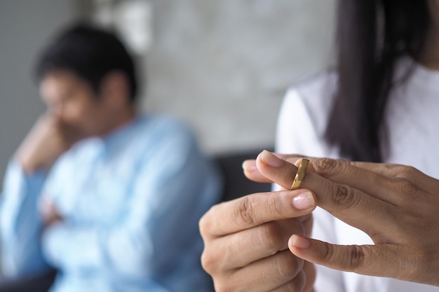 Die Hand einer traurigen Frau, die nach einem Streit mit dem Ehemann einen Ehering entfernt Das Konzept des Scheidungsliebesproblems