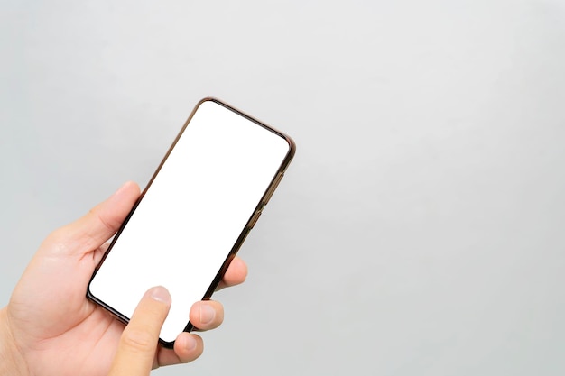Die Hand eines Mannes, die ein schwarzes Smartphone hält Touchscreen-Smartphone in einer Hand Grau isolierter Hintergrund