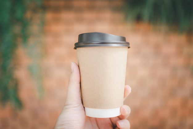 Die Hand eines Mannes hält morgens eine Tasse Kaffee