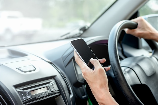 Die Hand von Männern benutzt Smartphones in Autos