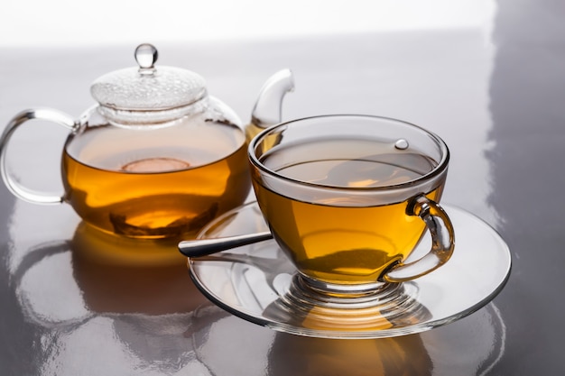 Foto die heiße teetasse und teekanne transparent auf dem tisch mit platz zum kopieren.