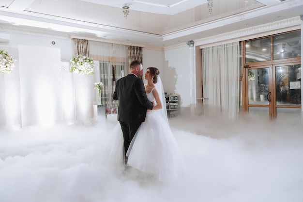 Foto die hochzeit der braut und des bräutigams in einem eleganten restaurant mit großem licht und atmosphäre der erste tanz der braut und des bräutigams