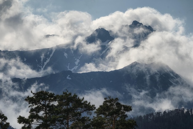 Die höchsten Gipfel der Berge bahnen sich ihren Weg durch die Wolken. Steine und Felsen. In den Bergen wandern. Schöne Natur.