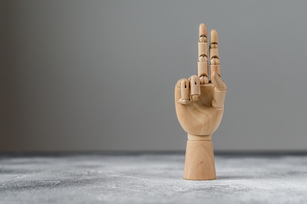 Die Holzhand zeigt zwei erhobene Finger. Das Konzept der Kommunikation.