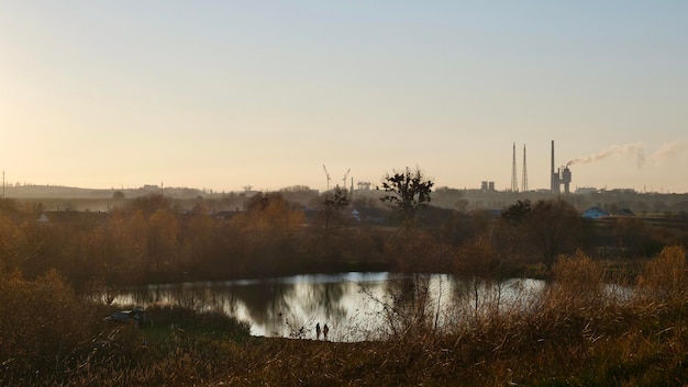 Die Industrieanlage arbeitet und verschmutzt die Umwelt Natur bei Sonnenuntergang Ökologische Weltkatastrophe von Fabriken