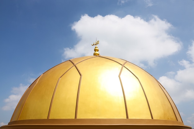 Die Inschrift ALLAH auf der goldenen Kuppel der Moschee mit Himmelshintergrund