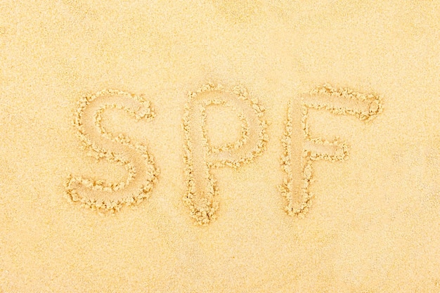 Die Inschrift auf dem Sand SPF Das Konzept der Anwendung von Sonnenschutzmitteln