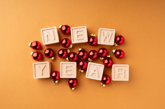 Die Inschrift Neujahr auf Holzwürfeln Holzwürfel mit Buchstaben und roten Kugeln Weihnachtsschmuck