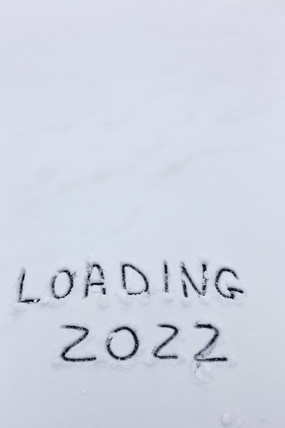 Die Inschrift über das neue Jahr 2022, die Zahlen und die Wortladung werden in der Wintersaison auf den Schnee geschrieben
