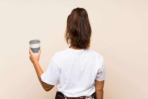 Die junge Angestelltfrau, die ein hält, nehmen Kaffee in der hinteren Position weg