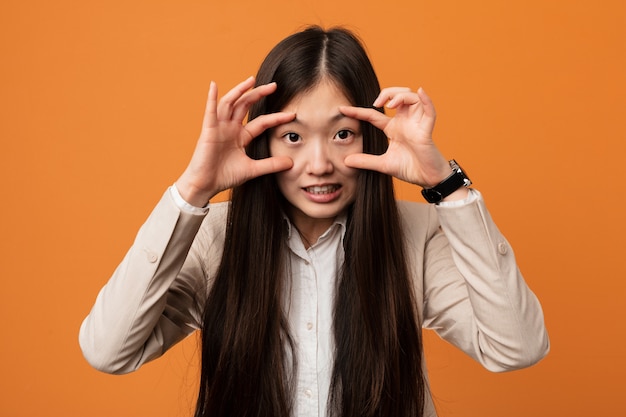 Die junge chinesische Frau des Geschäfts, die Augen hält, öffnete sich, um eine Erfolgschance zu finden.