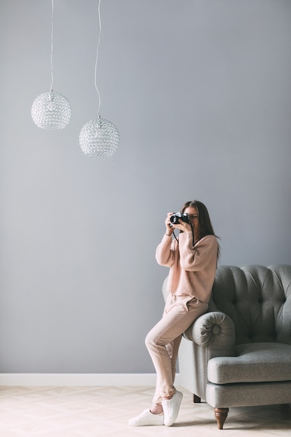 Die junge Frau des Fotografen hält Kamera und macht Foto zu Hause. Lebensstil