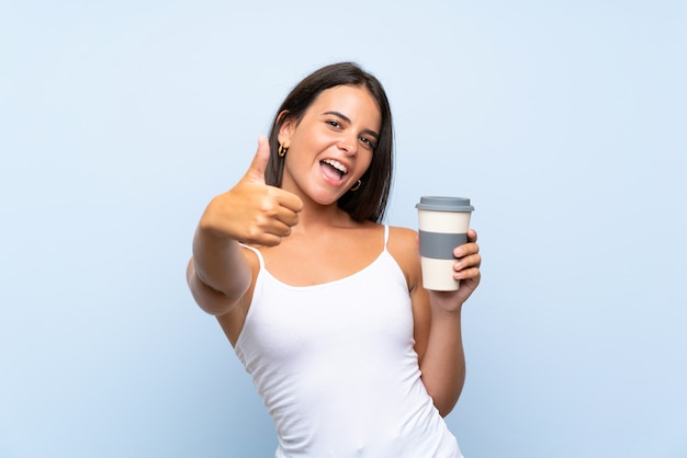 Die junge Frau, die ein hält, nehmen Kaffee mit den Daumen hoch