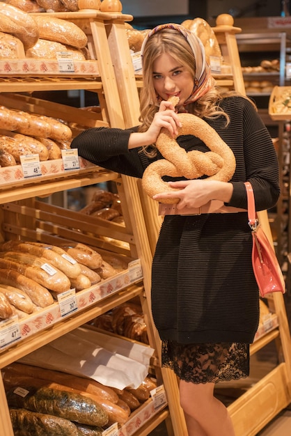 Die junge hübsche Frau in der Brotabteilung im Supermarkt