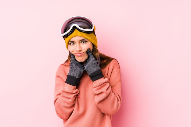 Die junge kaukasische Frau, die einen Ski trägt, kleidet das getrennte Zweifeln zwischen zwei Wahlen.