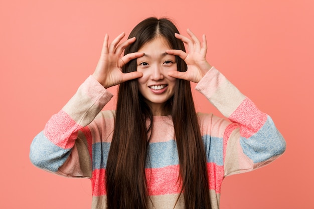 Die junge kühle chinesische Frau, die Augen hält, öffnete sich, um eine Erfolgschance zu finden