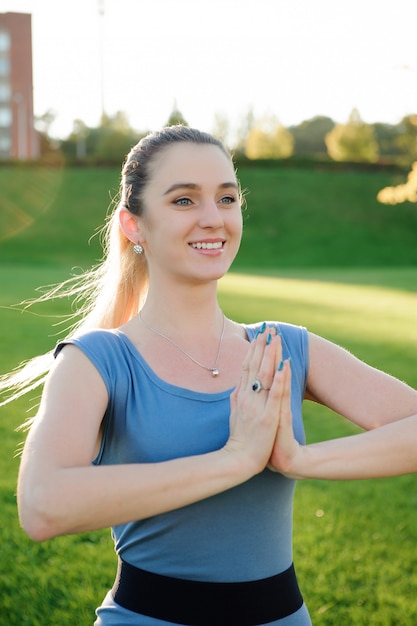 Die junge Schönheit, die Yoga tut, trainiert im Park