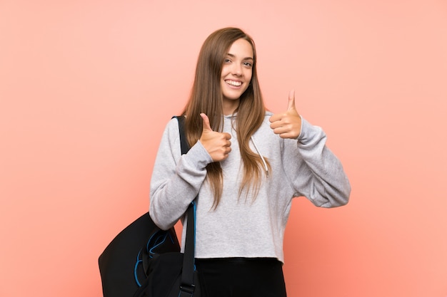 Die junge Sportfrau, die Daumen gibt, up Geste