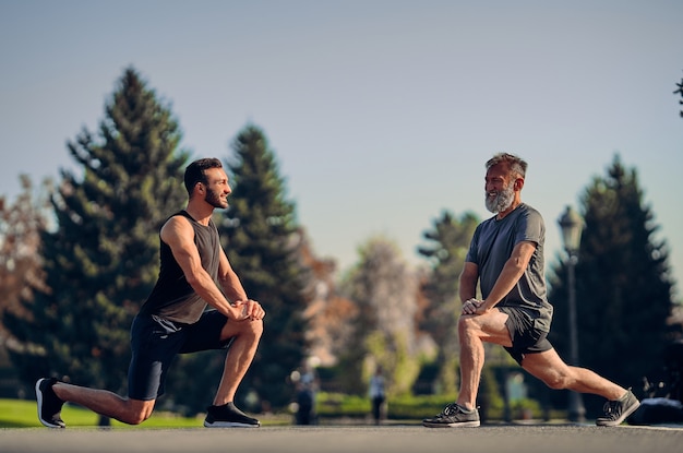 Die jungen und alten Sportler dehnen sich im Freien