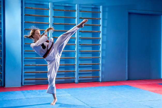 Die Karate-Frau mit schwarzem Gürtel Sportfrau kämpft mit einem Schlag im Sportuniformkleid Taekwondo-Karate