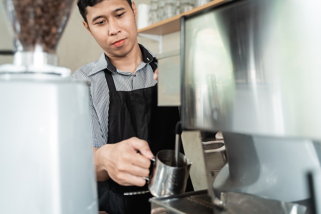 Die Kellnerin kocht Kaffee mit einer Kaffeemaschine