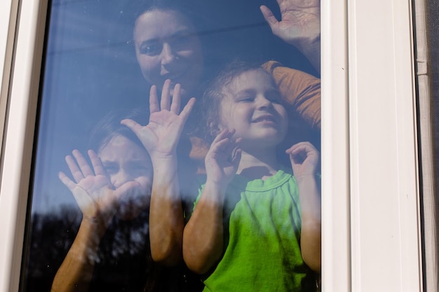 Die Kinder bleiben am Fenster und genießen das Wetter