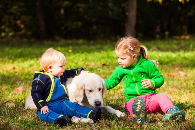 Die kleinen Geschwister gehen mit ihrem Hund spazieren