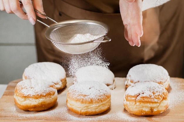 Die Köchin bereitet frische Donuts in ihrer Bäckerei zu Kochen traditionelles jüdisches Chanukka Sufganiyot Kleines Geschäftskonzept