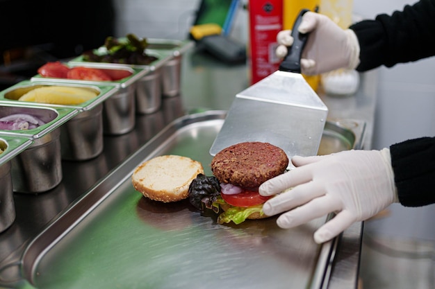 Die Köchin bereitet in ihrem Restaurant vegane Burger zu