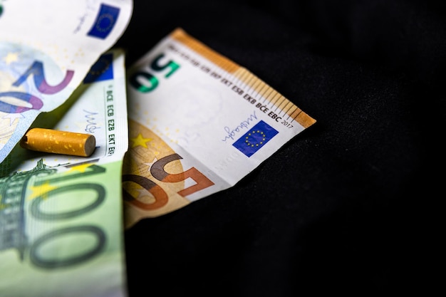 Foto die kosten für das rauchen von euro-banknoten und zigaretten