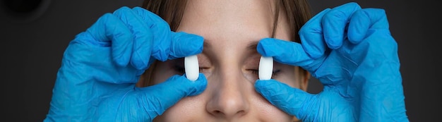 Die Krankenschwester bedeckt ihre Augen mit Tabletten