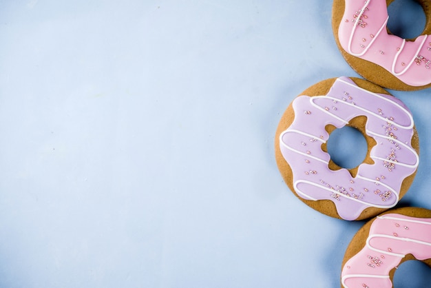 Die kreativen Bonbons legen, Nachtischkonzept mit Lutschern, Gelees, Süßigkeit, Plätzchenschaumgummiringen und kleinen Kuchen, hellblauer Hintergrund aus