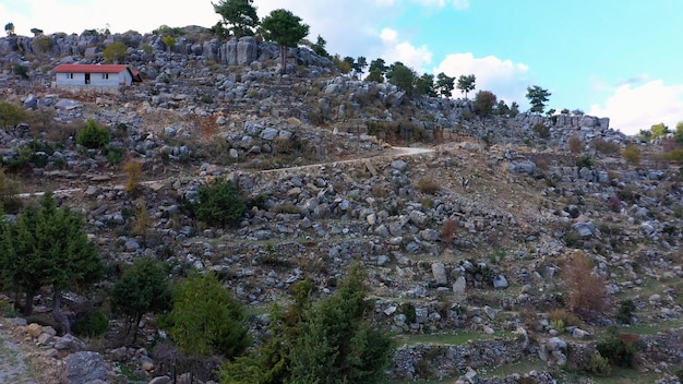 Die kurvenreiche Straße zwischen dem Rocky Mountains-Haus mit rotem Dach an einem Berghang mit Felsforma