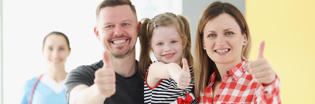 Foto die lächelnde familie, die im hintergrund die geste daumen hoch macht, ist arzt