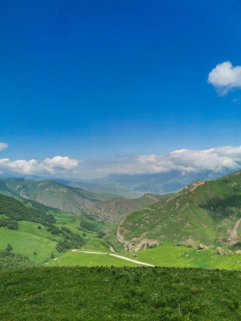 Die Landschaft des grünen Aktoprak-Durchlaufs im Kaukasus die Straße und die Berge unter grauen Wolken