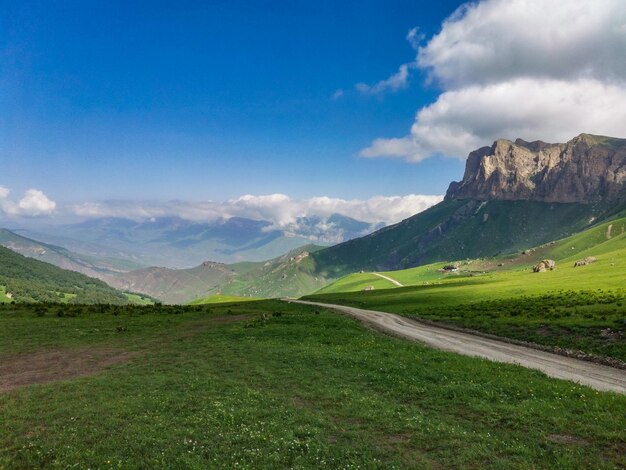 Die Landschaft des grünen Aktoprak-Durchlaufs im Kaukasus die Straße und die Berge unter grauen Wolken