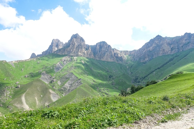 Die Landschaft des grünen Aktoprak Pass im Kaukasus die Straße und die Berge unter grauen Wolken KabardinoBalkarien Russland