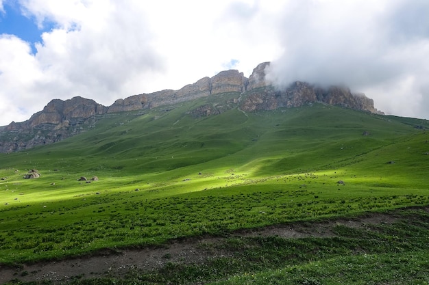 Die Landschaft des grünen Aktoprak Pass im Kaukasus die Straße und die Berge unter grauen Wolken KabardinoBalkarien Russland