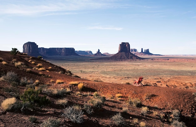 Die Landschaft und die erodierten Sandsteinkuppen und die Struktur des Monument Valley Ein einzelner Holzstuhl