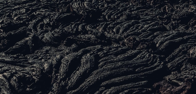 Die Lavaoberfläche kühlt ab und verhärtet sich zu Gesteinsklumpen dunkelschwarzer Lava