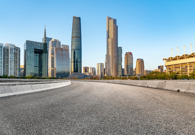 Die leere Asphaltstraße wird entlang moderner Geschäftsgebäude in Chinas Städten gebaut.