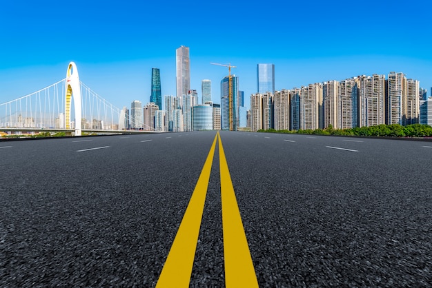 Die leere Asphaltstraße wird entlang moderner Geschäftsgebäude in Chinas Städten gebaut.