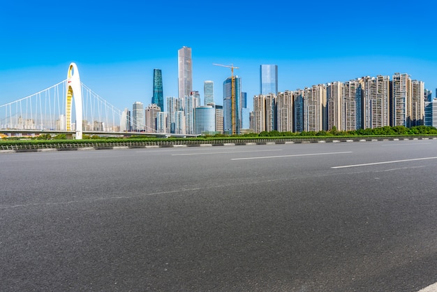 Die leere Asphaltstraße wird entlang moderner Geschäftsgebäude in Chinas Städten gebaut.