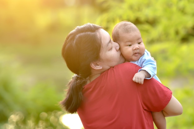 Die leibliche Mutter küsste glücklich die Wangen eines neugeborenen Babys.