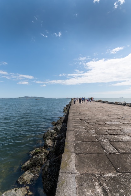 Die Leute gehen auf dem Great South Walk am Leuchtturm von Pollbeg.