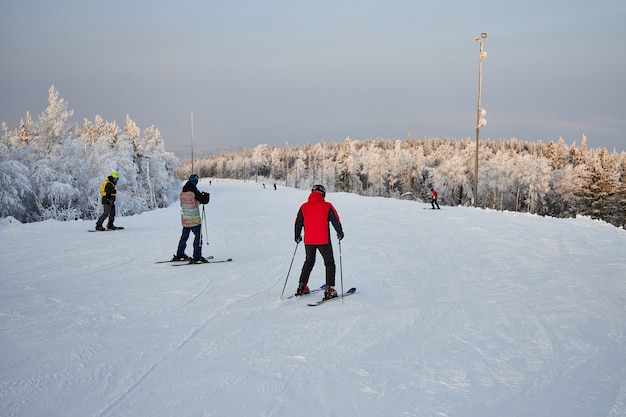 Die Leute gehen Snowboarden und Skifahren, Wintererholung und Sport. Skifahren auf einem Snowboard den Berg hinunter, lustige Gefühle auf den Gesichtern von Männern und Frauen