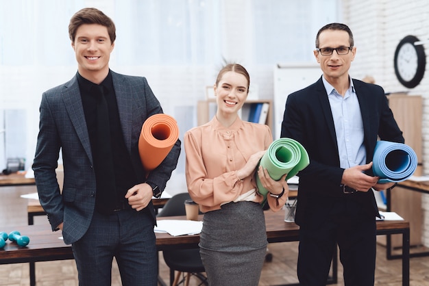 Die Leute halten Gymnastikmatten auf der Arbeit.